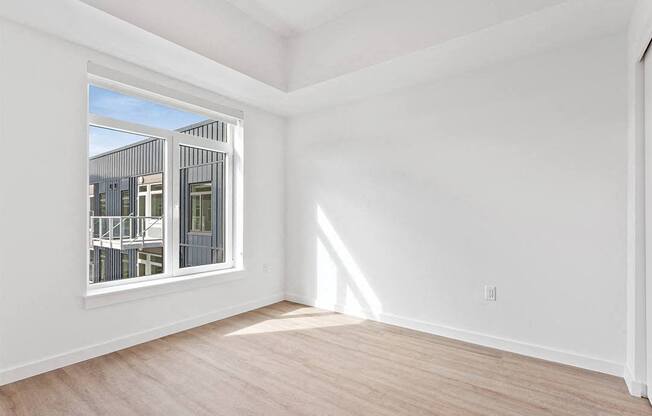 a living room with a large window and wooden floors