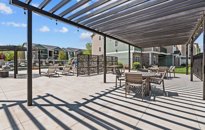 A patio with a table and chairs under a roof.