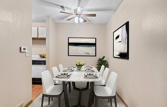 a dining room with a table and chairs and a ceiling fan