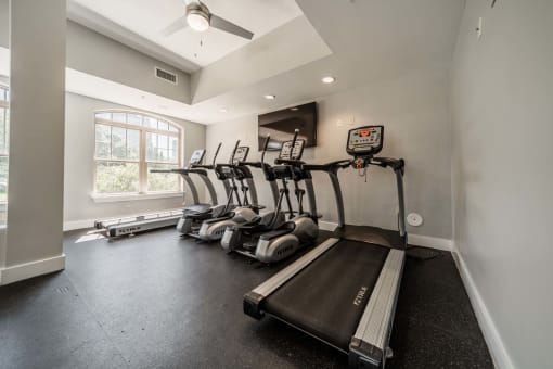 the gym has plenty of cardio equipment and a window