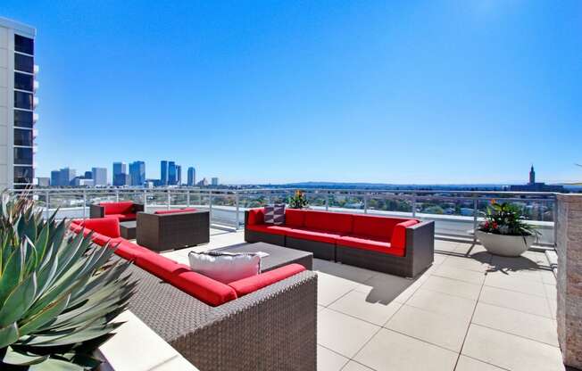 a rooftop terrace with couches and chairs and a view of the city