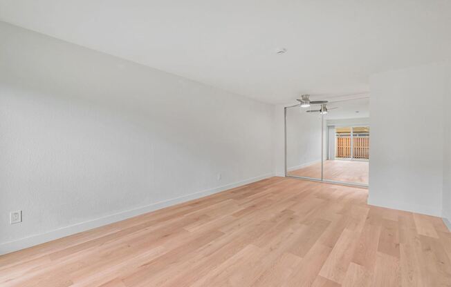A room with wooden flooring and white walls.