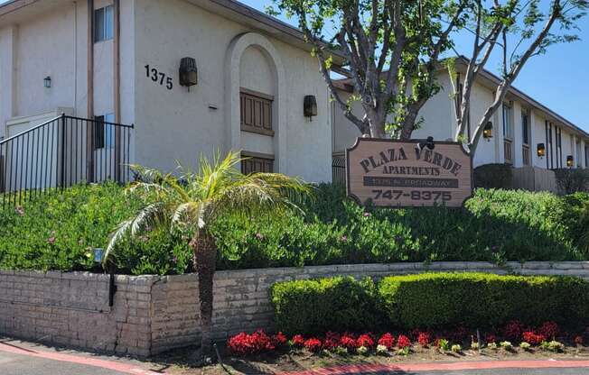 Gated front enterance with lush gardens at Plaza Verde Apartments in  Escondido, California.