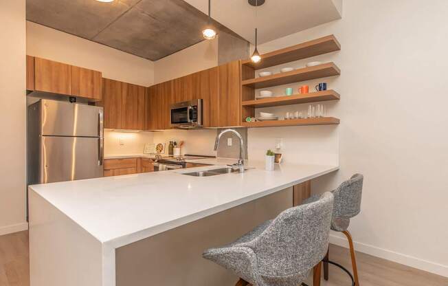 A kitchen with a white countertop and a stainless steel refrigerator.