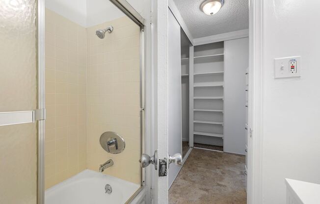 a bathroom with a bathtub and a walk in closet