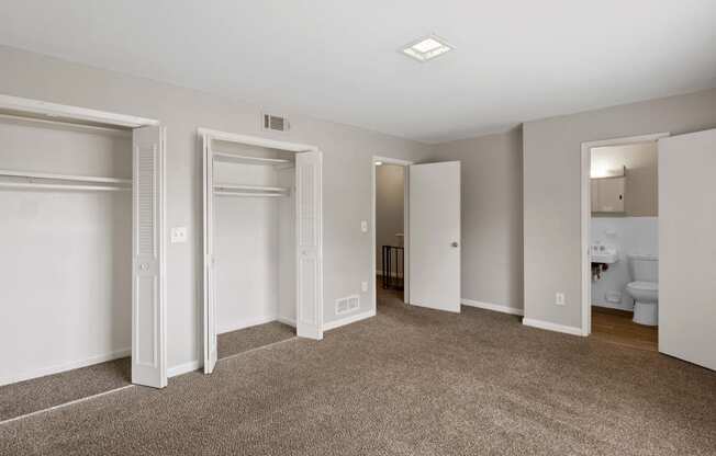 an empty bedroom with three closets and a bathroom