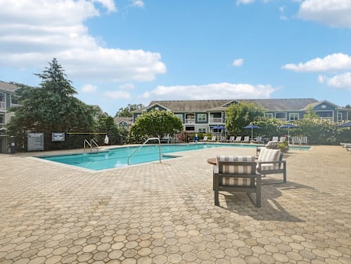 Resort-style pool deck and outdoor lounge seating at Village at Broadstone Station apartments in Apex, NC