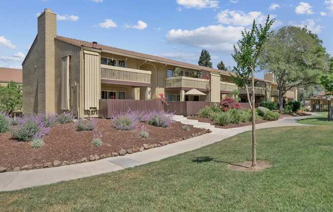 an exterior view of a building with a sidewalk and grass at Summerwood Apartments, California