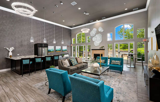 a living room with couches and chairs and a kitchen with a fireplace