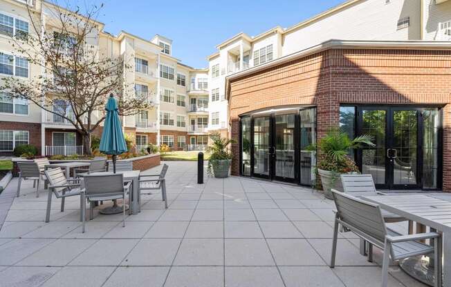 a patio with tables and chairs in front of an apartment building  at The Lena, New Jersey