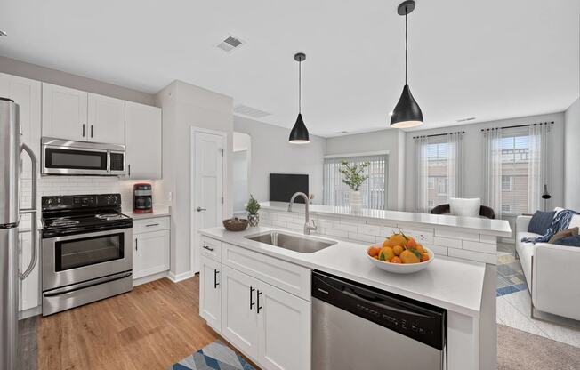 a white kitchen with a large counter top and a sink