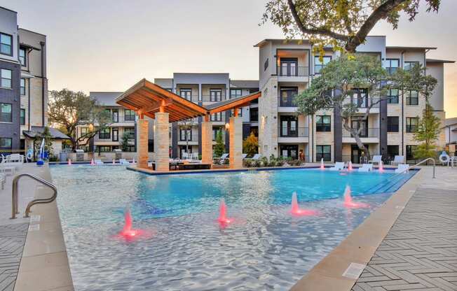 The resort style pool lit up at night at Windsor Ridge, Austin, TX