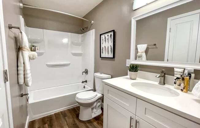 A white toilet sits in a bathroom next to a white sink.