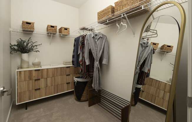 a walk in closet with a mirror and clothes rack