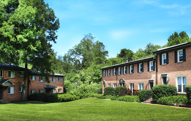 green lawn in front of a brick apartment building