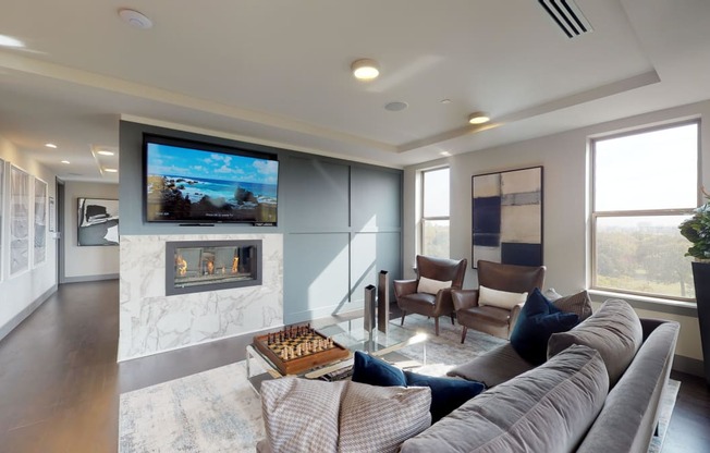 Resident sky lounge facing a table and sitting area complete with a television and fireplace.