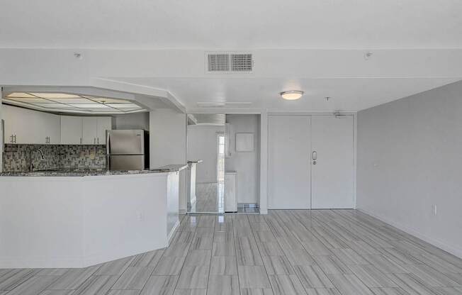A room with a bar area and a kitchenette.