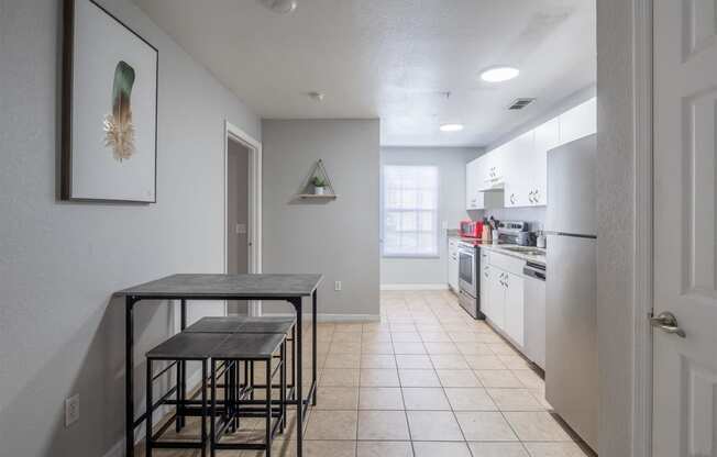 an empty kitchen with a dining table and stools
