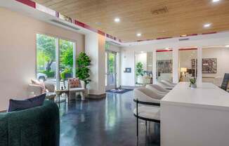 A white reception desk with a green chair in front of it.