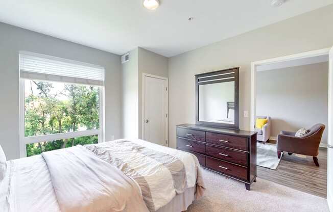 a bedroom with a bed and a dresser and a window