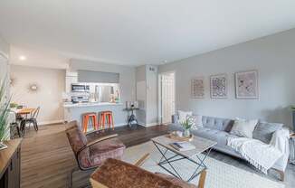 A living room with a grey couch and a brown chair.