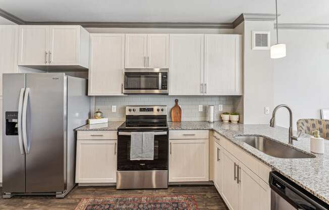 a kitchen with white cabinets and stainless steel appliances