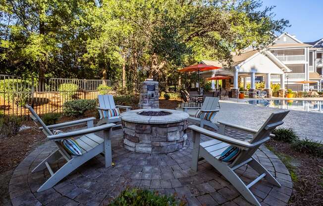 a patio with chairs and a fire pit and a pool