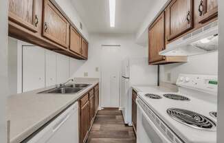 A kitchen with white appliances and wooden cabinets.