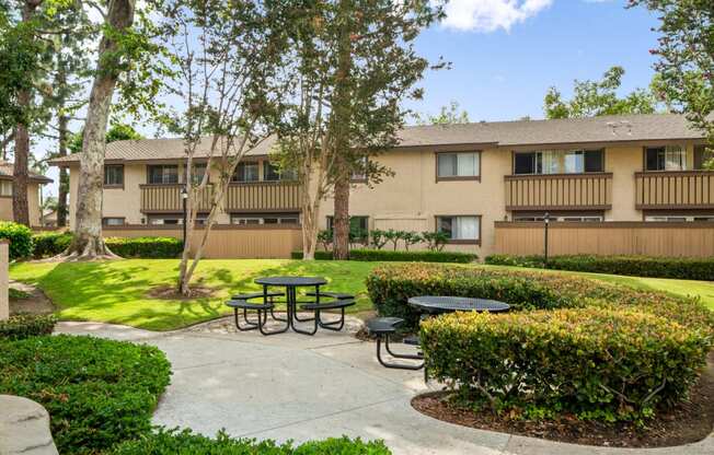 a patio with tables in front of an apartment building