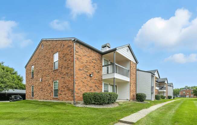 A brick house with a white garage door and a white house next to it.