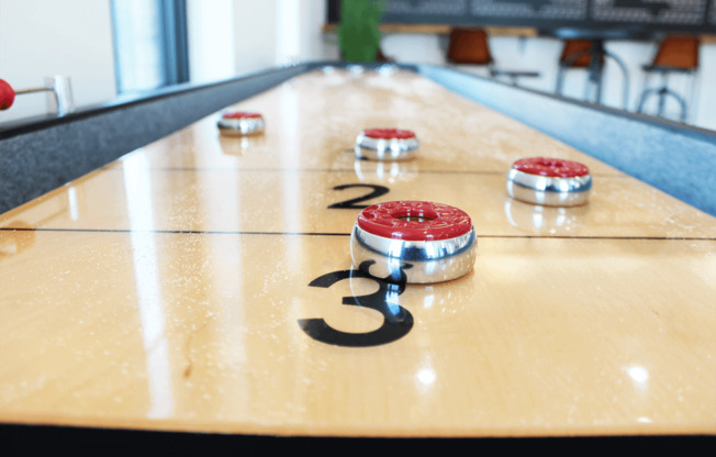 a shuffleboard court with red and white balls on it