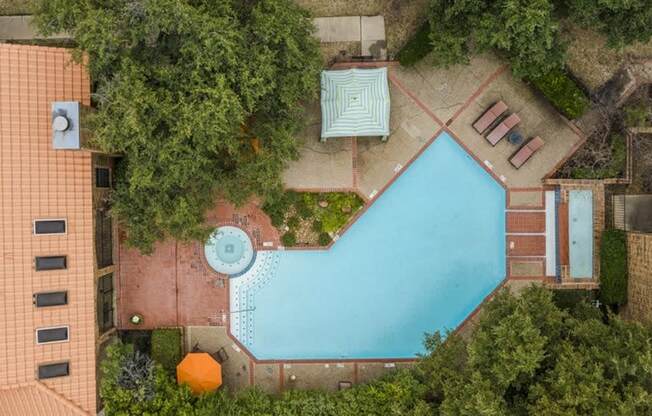 an aerial view of a swimming pool in the backyard of a house