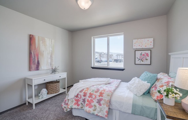 Bedroom with accent table, window and full size bed. at Altitude, East Wenatchee, Washington