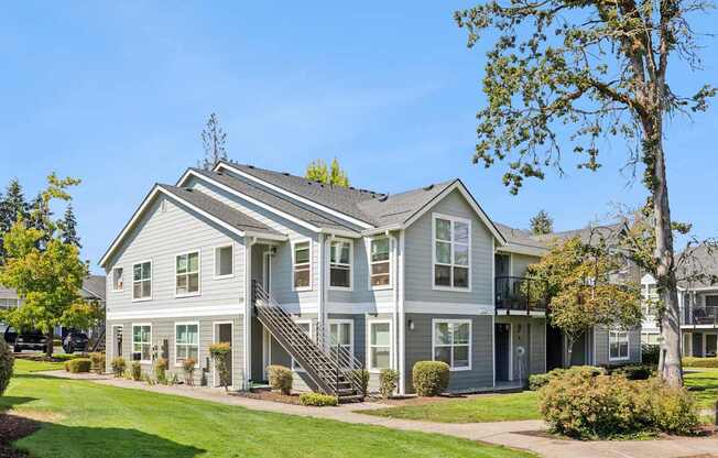 A large grey house with a white door and windows.
