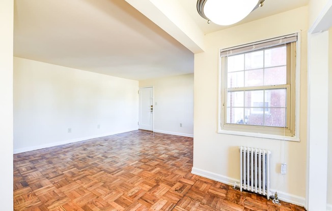 vacant living area with hardwood flooring and large windows at richman apartments in washington dc