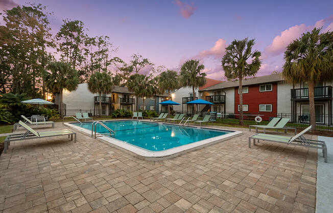 Community Swimming Pool with Pool Furniture at Heron Walk Apartments in Jacksonville, FL.