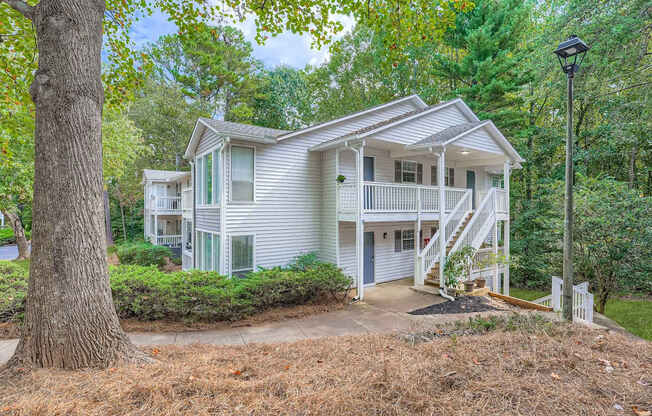 A house with a white exterior and a green lawn.