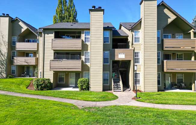 an exterior view of an apartment building with a green lawn