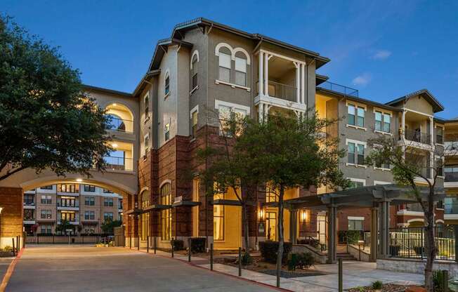 A large apartment complex with a courtyard and trees.