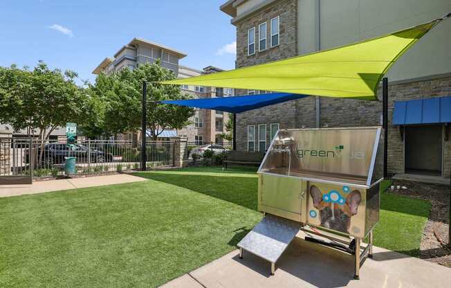 Bark park with shaded area and a pet wash station at GreenVue apartments in Richardson, TX