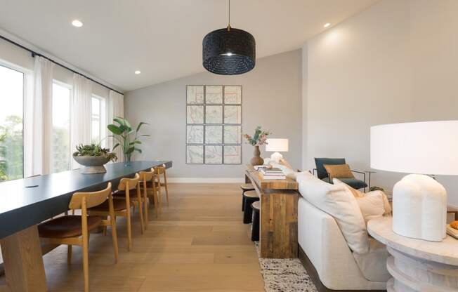a living room and dining room with a long table and a couch
