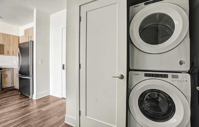 A white door is open to a laundry room with a washer and dryer.