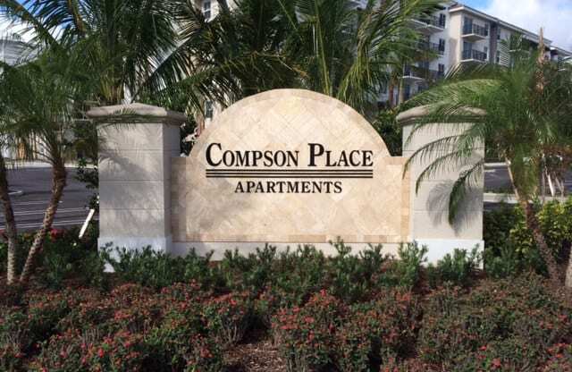 a sign for compass place apartments in front of palm trees