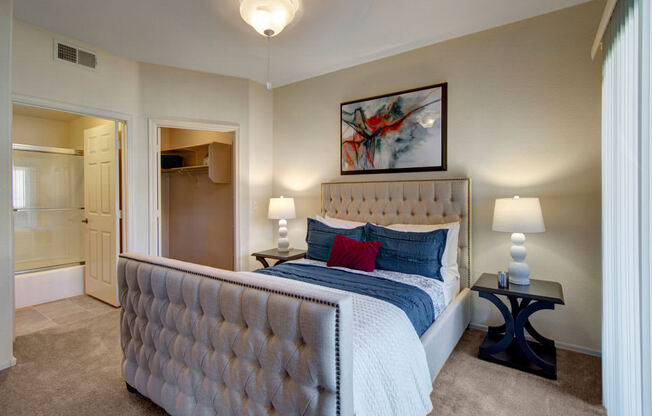 A bedroom with a large bed and a painting on the wall.