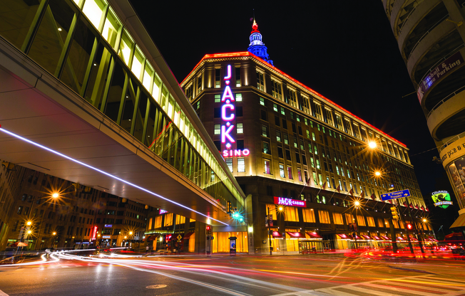 A long exposure shot of a city street at night with the Jack London building illuminated.