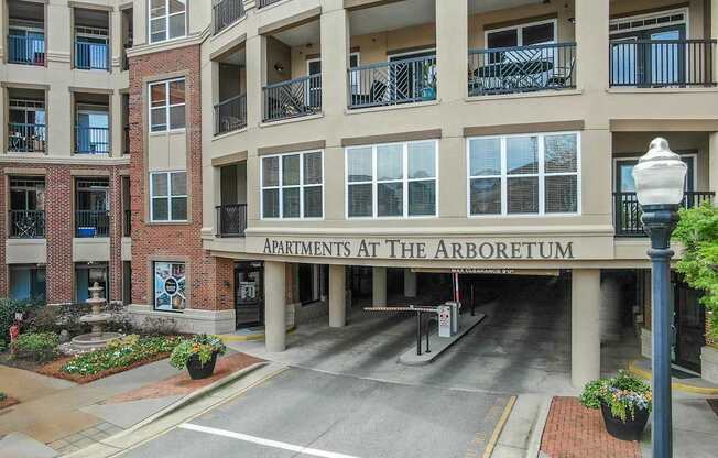The Arboretum Apartments building has a brick facade and is surrounded by greenery.