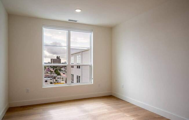 A large empty room with a view of the city.