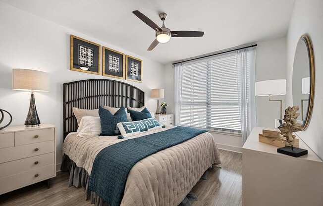 Serene bedroom with a statement headboard, ceiling fan, and oversized window for soft natural light