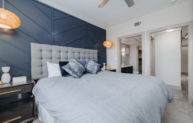 a bedroom with a large bed and a blue accent wall