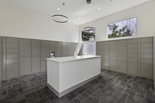 a large room with a counter in the middle and a row of lockers on the wall  at Camelot Apartment Homes, Everett, 98204